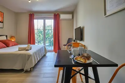 a room with a bed and a table with a plate of food at Au Céladon Parking gratuit, WIFI, Terrasse, Piscine in Carcassonne