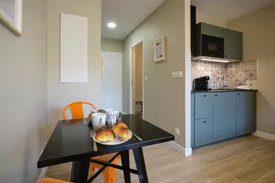 a table with a plate of food on it in a kitchen at Au Céladon Parking gratuit, WIFI, Terrasse, Piscine in Carcassonne