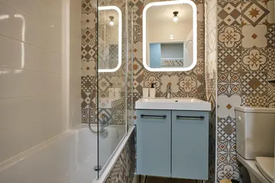 a bathroom with a sink and a tub and a mirror at Au Céladon Parking gratuit, WIFI, Terrasse, Piscine in Carcassonne