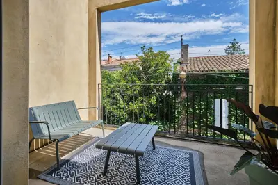 a blue bench and a table on a balcony at Au Céladon Parking gratuit, WIFI, Terrasse, Piscine in Carcassonne