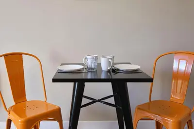 a black table with two chairs and two glasses on it at Au Céladon Parking gratuit, WIFI, Terrasse, Piscine in Carcassonne