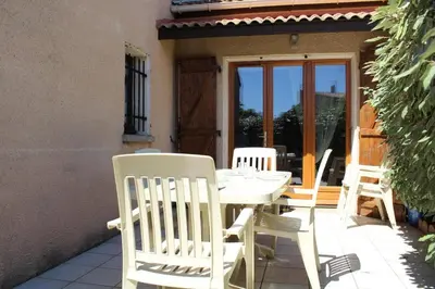 a white table and chairs on a patio at Maison 3 pièces 6 couchages PORT LA NOUVELLE PN340-040 in Port-la-Nouvelle