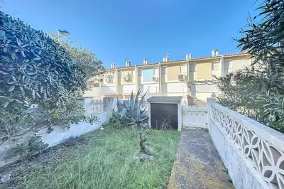 a large yellow building with a gate in the yard at Bright Family Home Near the Sea in Port-la-Nouvelle