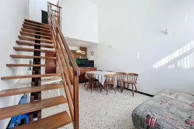 a staircase in a room with a table and chairs at Bright Family Home Near the Sea in Port-la-Nouvelle