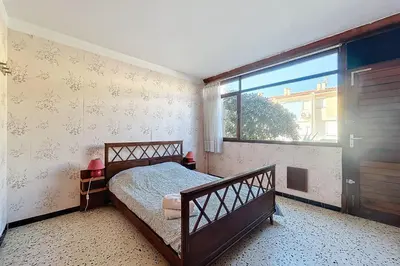 a bedroom with a bed and a large window at Bright Family Home Near the Sea in Port-la-Nouvelle