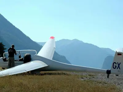 a man standing next to a small plane in a field at Cozy Family Getaway Home in Quillan