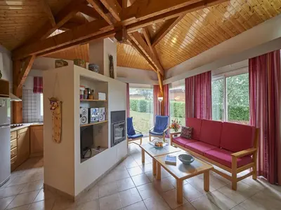 a living room with a red couch and a table at Cozy Family Getaway Home in Quillan
