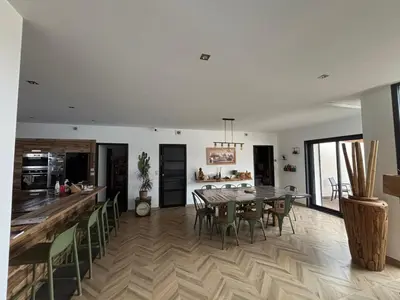 a kitchen and dining room with a table and chairs at Villa paisible au bord des vignes in Sallèles-dʼAude