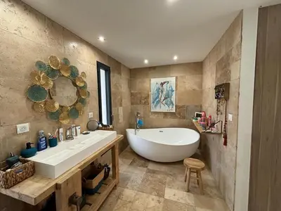 a bathroom with a large white tub and a sink at Villa paisible au bord des vignes in Sallèles-dʼAude