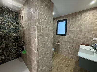 a bathroom with a sink and a toilet and a window at Villa paisible au bord des vignes in Sallèles-dʼAude