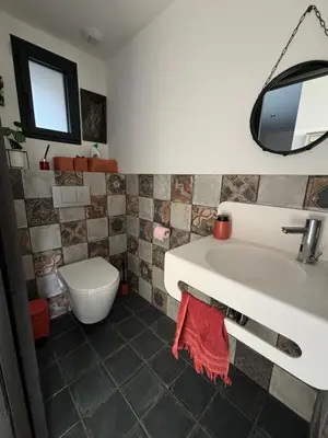 a bathroom with a tub and a toilet and a sink at Villa paisible au bord des vignes in Sallèles-dʼAude
