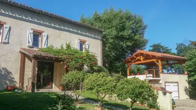 a house with a gazebo on the side of it at Le COULOUMIER côté lac in Caignac