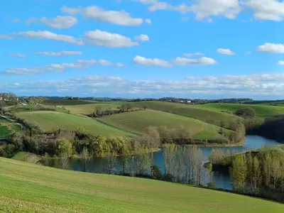 a view of the fields and a river at Le COULOUMIER côté lac in Caignac