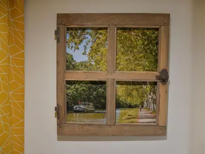 a window on a wall with a view at Le COULOUMIER côté lac in Caignac
