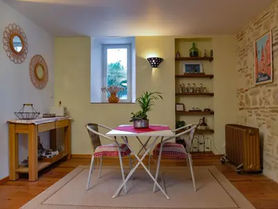 a dining room with a table and two chairs at Le COULOUMIER côté lac in Caignac