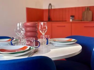 a table with plates and wine glasses on it at Appartement Thème Années 60' l Baignoire Jets l Clim l Netflix in Castres