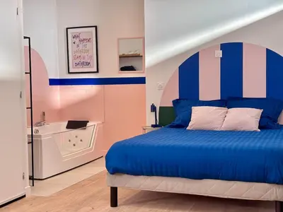 a bedroom with a blue bed and a bath tub at Appartement Thème Années 60' l Baignoire Jets l Clim l Netflix in Castres