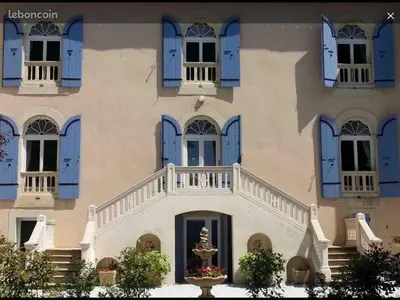 a building with blue shuttered windows and a staircase at Ferrabouc in Mas-Saintes-Puelles