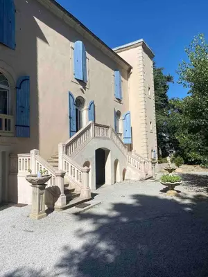 a large house with a staircase in front of it at Ferrabouc in Mas-Saintes-Puelles