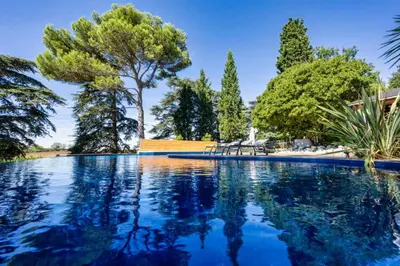 a swimming pool with trees in the background at Ferrabouc in Mas-Saintes-Puelles