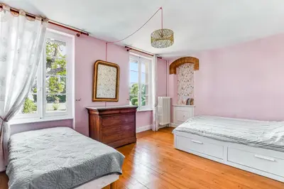 a bedroom with two beds and a mirror at Maison de famille Lafonsèque in Renneville