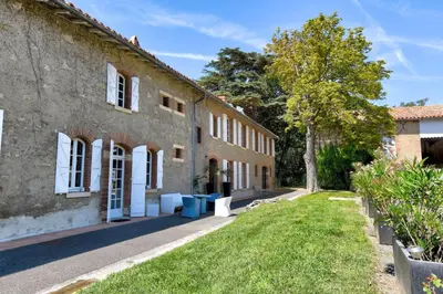 an old building with a tree next to it at Maison de famille Lafonsèque in Renneville