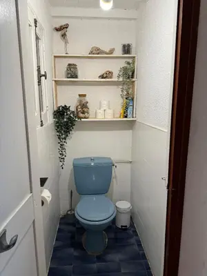 a bathroom with a blue toilet in a small room at La maison Auguste - vue imprenable sur la Cité in Carcassonne