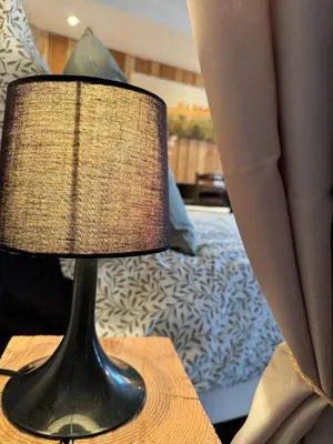 a black lamp sitting on a table next to a bed at La maison Auguste - vue imprenable sur la Cité in Carcassonne