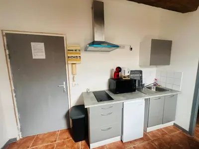 a small kitchen with a sink and a counter top at Grand studio proche centre in Narbonne