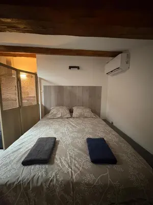 a bedroom with a bed with two towels on it at Grand studio proche centre in Narbonne