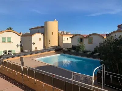 a swimming pool on the side of a building at Fleur Australe in Gruissan