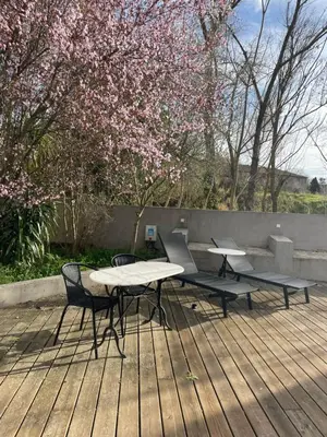 a picnic table and two chairs on a wooden deck at La Tuilerie du Bazalac in Trèbes