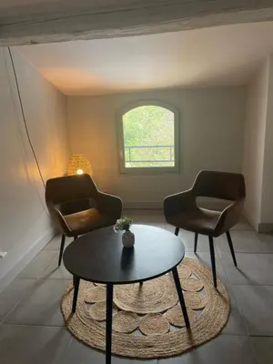 a living room with two chairs and a table at La Tuilerie du Bazalac in Trèbes