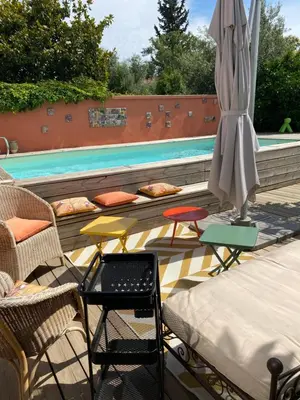a patio with a table and an umbrella and a pool at Chez Martine Côté Cité in Carcassonne