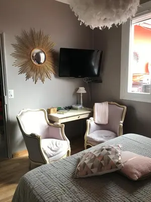 a bedroom with a bed and two chairs and a desk at Chez Martine Côté Cité in Carcassonne