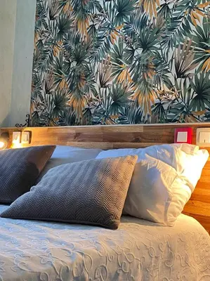 a bedroom with a bed with a large painting on the wall at La Cour des Grands in Revel