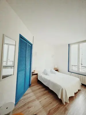 a bedroom with a bed and a blue door at La Cour des Grands in Revel