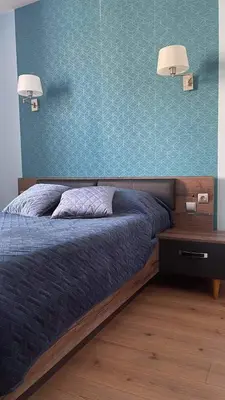 a bedroom with a bed and a blue wall at La Cour des Grands in Revel