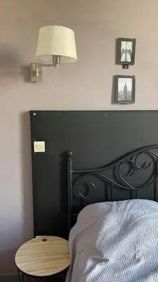 a bedroom with a bed with a black headboard and a lamp at La Cour des Grands in Revel