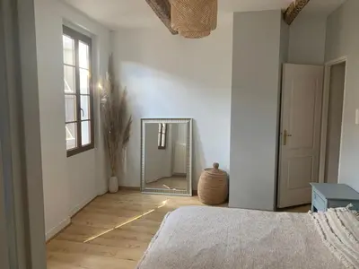 a bedroom with a mirror and a bed in a room at Cocon mazerien in Mazères
