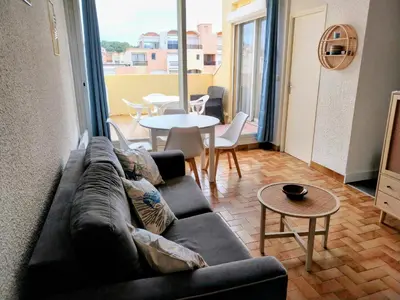 a living room with a couch and a table at Le Quai401 YourHostHelper in Gruissan