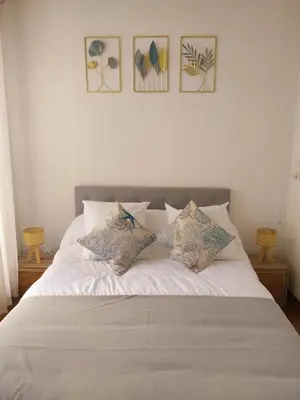 a white bed with four pillows on top of it at Le Quai401 YourHostHelper in Gruissan