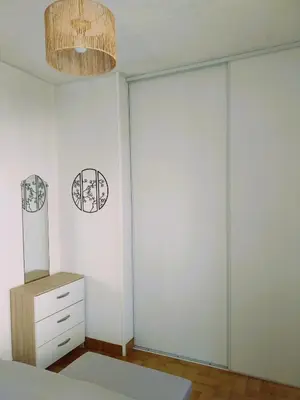a bedroom with sliding glass doors and a dresser at Le Quai401 YourHostHelper in Gruissan