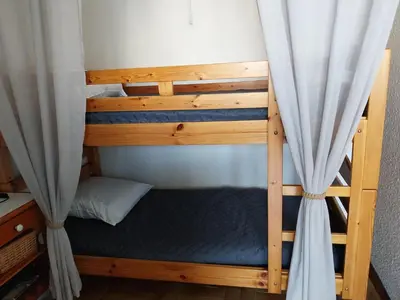 a couple of bunk beds in a room with curtains at Le Quai401 YourHostHelper in Gruissan