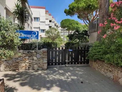 a street sign in front of a building at T2 cabine relooké avec piscine idéalement situé in Gruissan