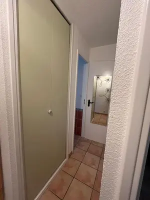 a hallway with a glass door and a tile floor at T2 cabine relooké avec piscine idéalement situé in Gruissan
