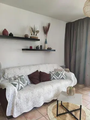 a living room with a couch and a table at T2 cabine relooké avec piscine idéalement situé in Gruissan