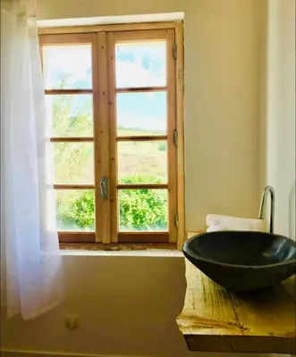 a bathroom with a black sink and a window at Demeure Charmante avec Piscine privée au coeur des Vignes in Quarante