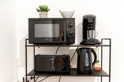 a microwave and a coffee maker on a shelf at Le Central - tout à pied - wifi in Carcassonne