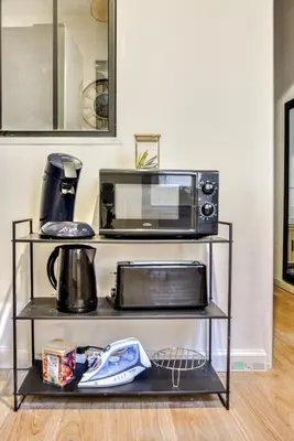 a microwave oven sitting on a shelf with a microwave at Le Central - tout à pied - wifi in Carcassonne